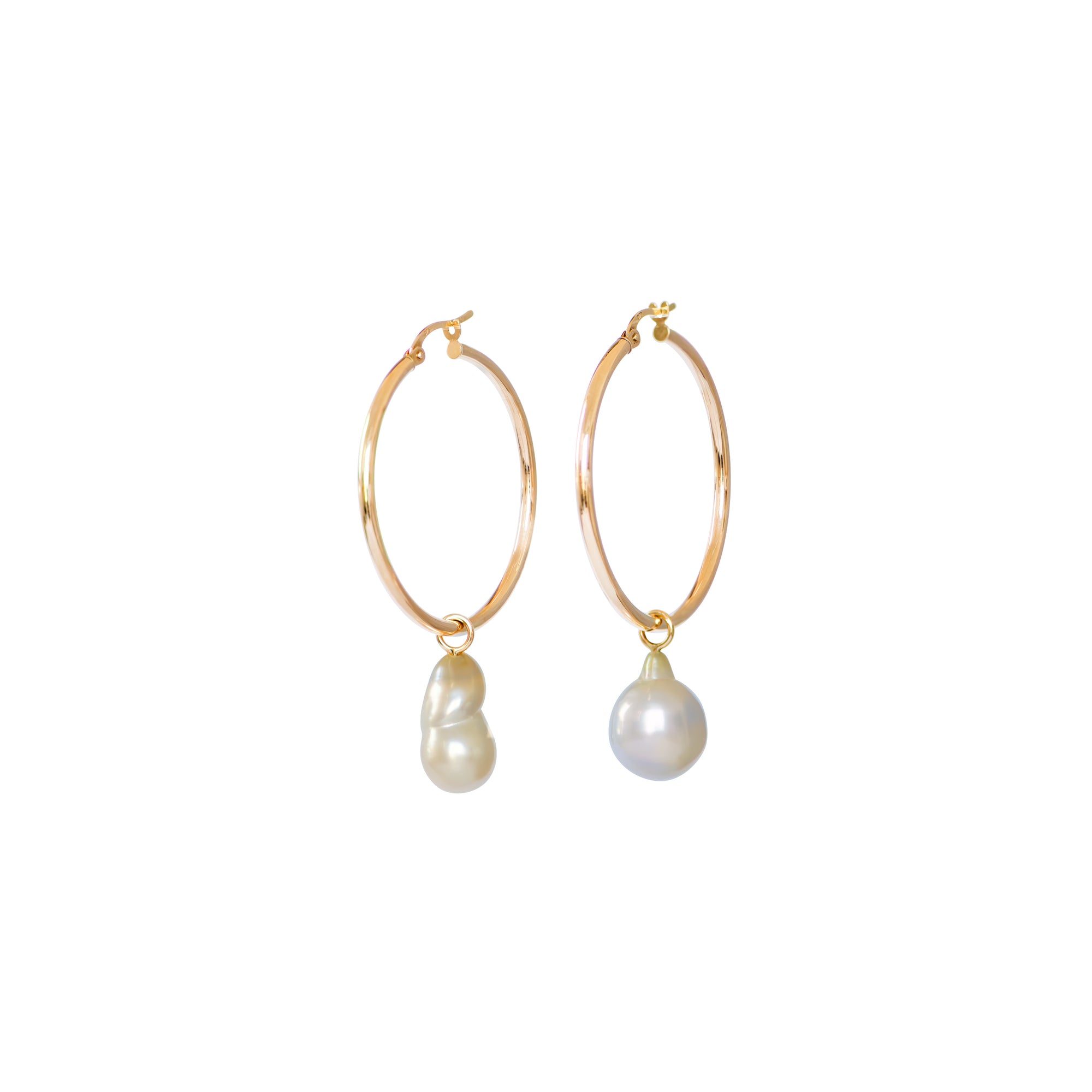 Hand selected unique baroque white and golden South Sea pearls, in a hand crafted yellow gold detachable setting, on medium yellow gold high polish hoop earrings, displayed on a white background.