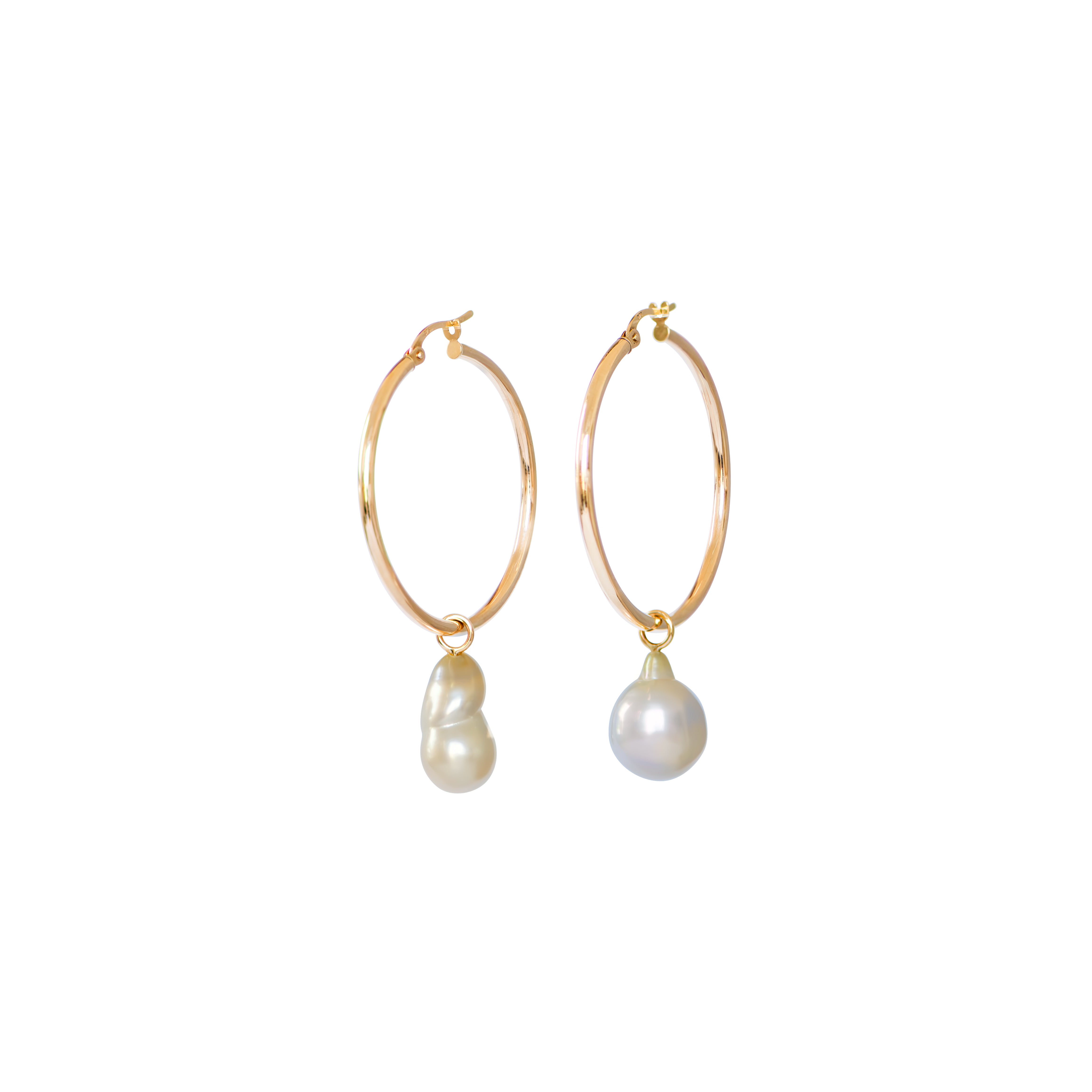 Hand selected unique baroque white and golden South Sea pearls, in a hand crafted yellow gold detachable setting, on medium yellow gold high polish hoop earrings, displayed on a white background.