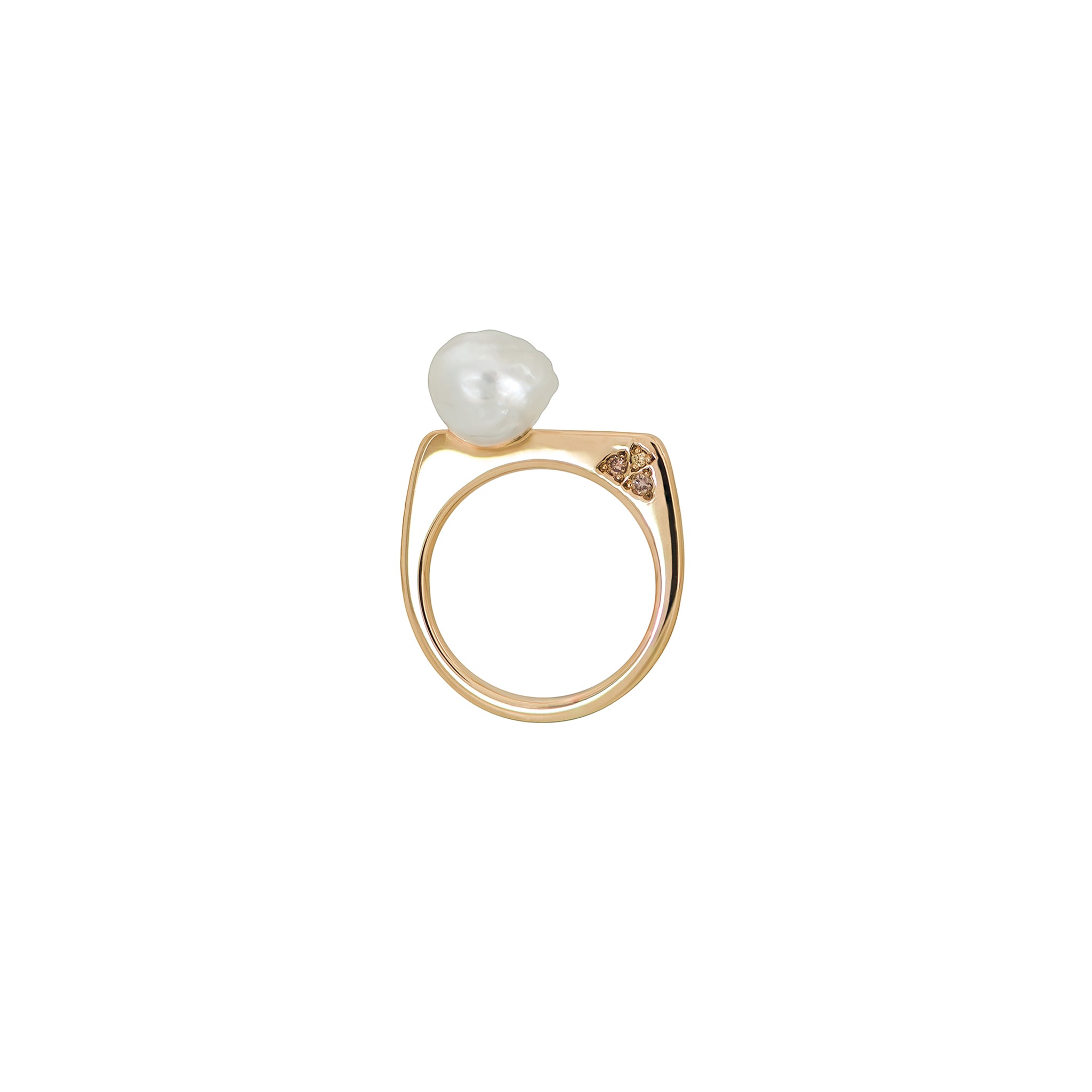 A yellow gold ring featuring a baroque South Sea pearl and a trio of Australian champagne diamonds in earthy coloured tones is displayed on a white background.